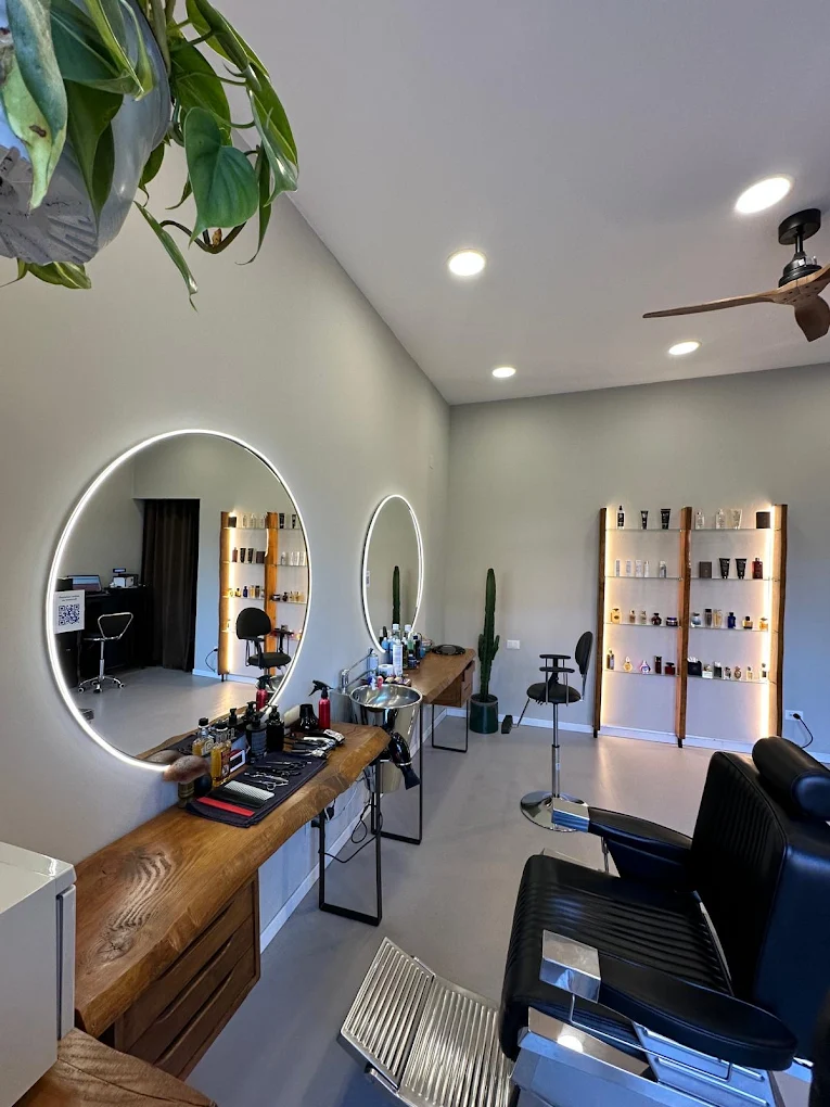 Postazione da barbiere moderna da Feivèr Barber Treviglio con esposizione prodotti e finiture in legno.